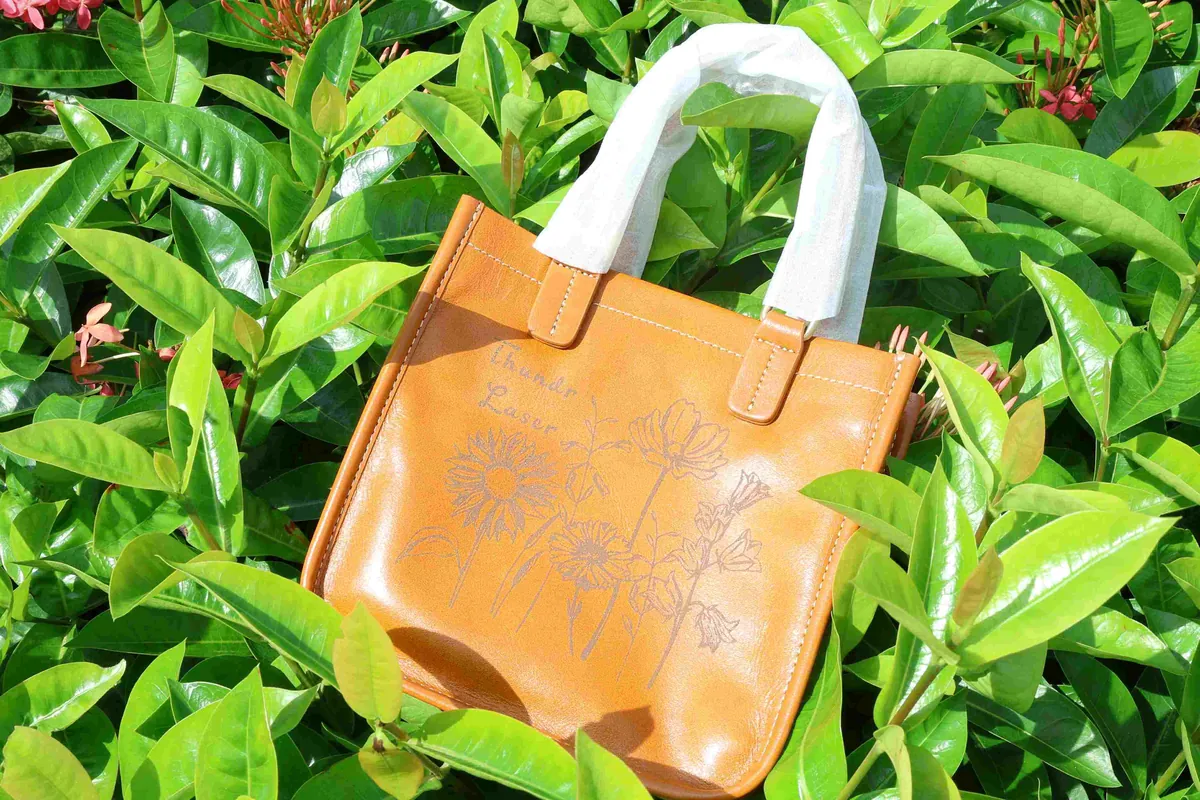Borsa in pelle con decoro floreale inciso